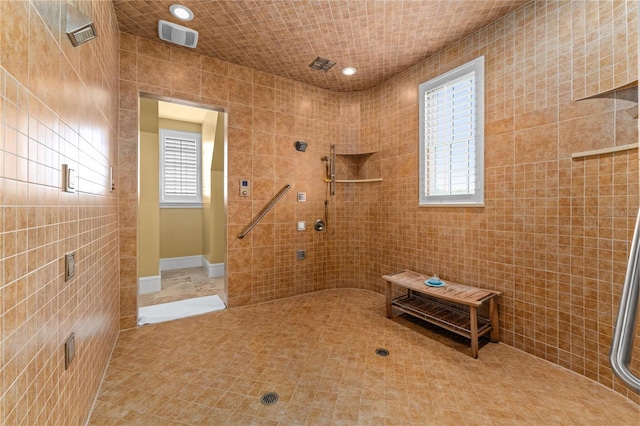 bathroom featuring visible vents, tile patterned floors, a tile shower, tile walls, and recessed lighting