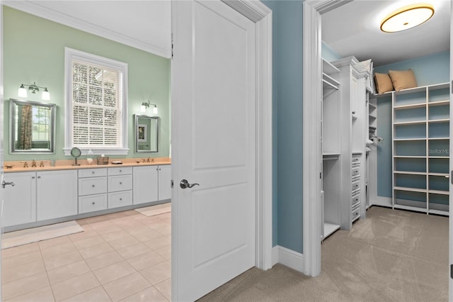 spacious closet featuring light colored carpet, a sink, and light tile patterned floors