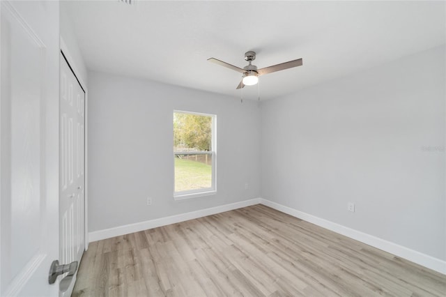 unfurnished bedroom with light wood-type flooring, a ceiling fan, baseboards, and a closet