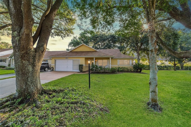 ranch-style home with a yard and a garage