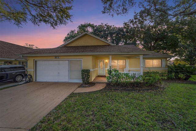 view of front of house with a porch, a yard, and a garage