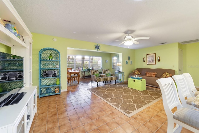 tiled living room featuring a textured ceiling and ceiling fan