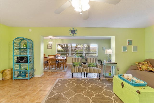 interior space with a textured ceiling, tile patterned flooring, and ceiling fan