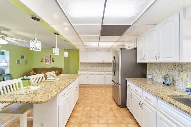 kitchen featuring tasteful backsplash, a breakfast bar, and white cabinets