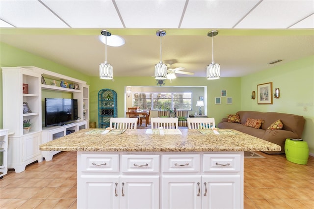 kitchen with white cabinetry, decorative light fixtures, and a kitchen bar