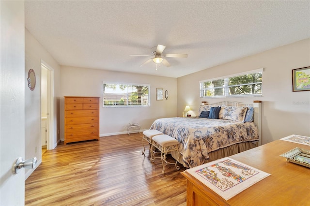 bedroom with light hardwood / wood-style flooring, a textured ceiling, and ceiling fan