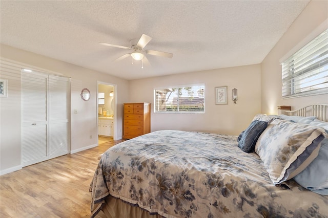 bedroom with connected bathroom, a closet, light wood-type flooring, a textured ceiling, and ceiling fan