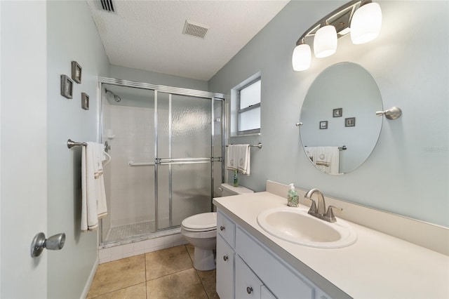 bathroom featuring vanity, tile patterned flooring, toilet, and an enclosed shower