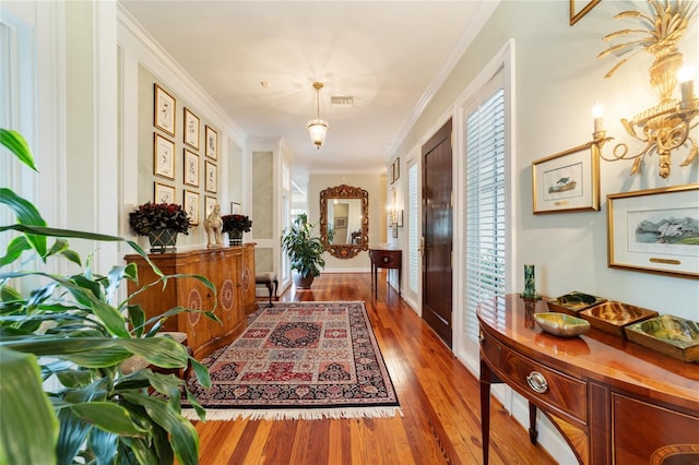 hallway with ornamental molding and hardwood / wood-style floors