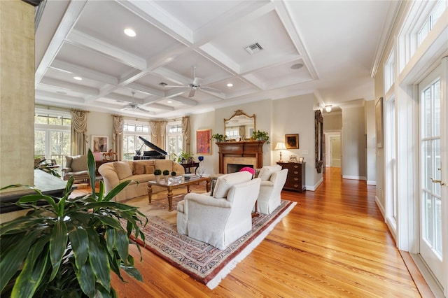 living room with beamed ceiling, coffered ceiling, light hardwood / wood-style floors, and ceiling fan