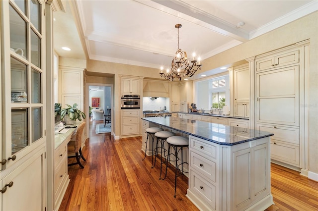 kitchen featuring hardwood / wood-style floors, a center island, a breakfast bar, and oven