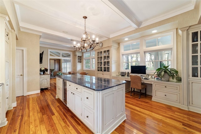 kitchen with light hardwood / wood-style floors, a center island, built in desk, and pendant lighting