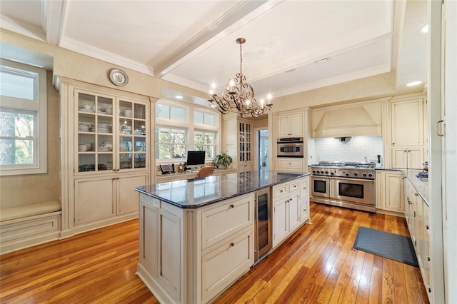 kitchen featuring custom range hood, stainless steel appliances, light wood-type flooring, and plenty of natural light