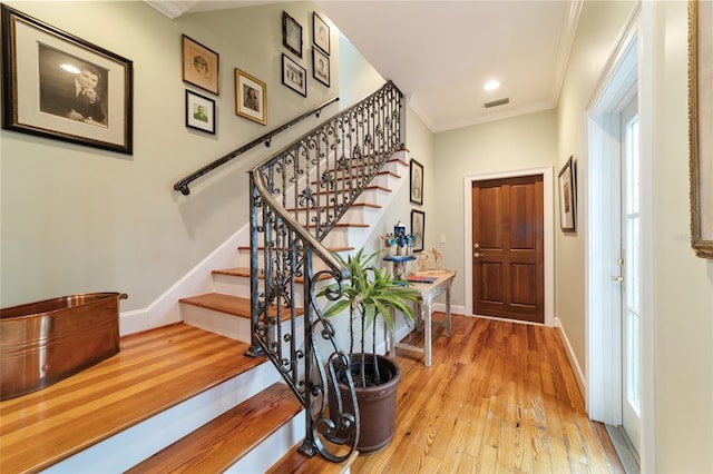 entryway featuring ornamental molding and light wood-type flooring