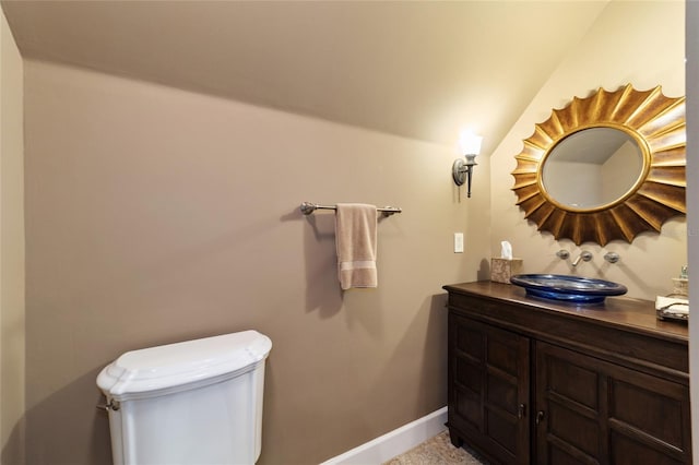 bathroom with vanity, lofted ceiling, and toilet