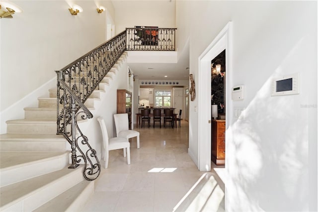 foyer with a towering ceiling and tile patterned flooring