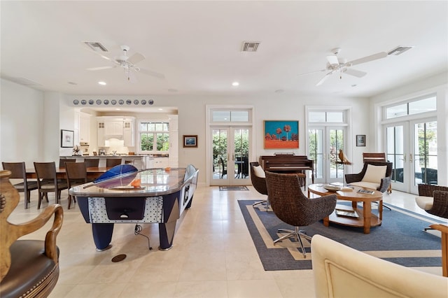 tiled living room with french doors and ceiling fan