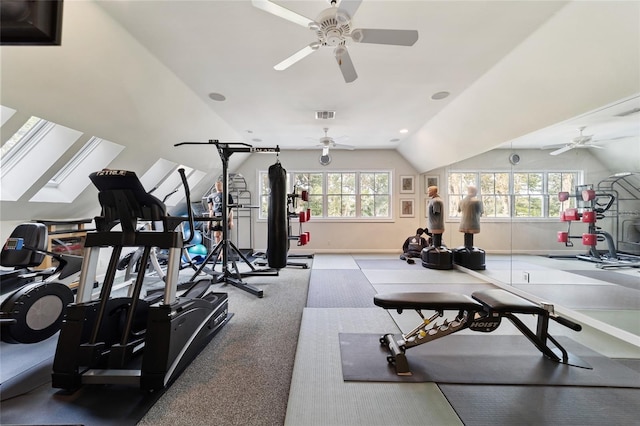 workout room featuring vaulted ceiling with skylight, ceiling fan, and plenty of natural light