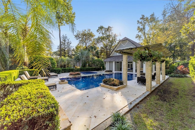 view of swimming pool featuring a patio area and an in ground hot tub