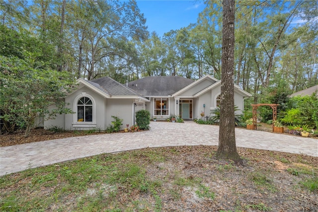 view of front of house with stucco siding, decorative driveway, and a garage