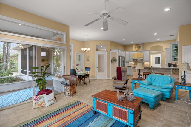 living room with light tile patterned flooring, recessed lighting, ceiling fan with notable chandelier, and visible vents