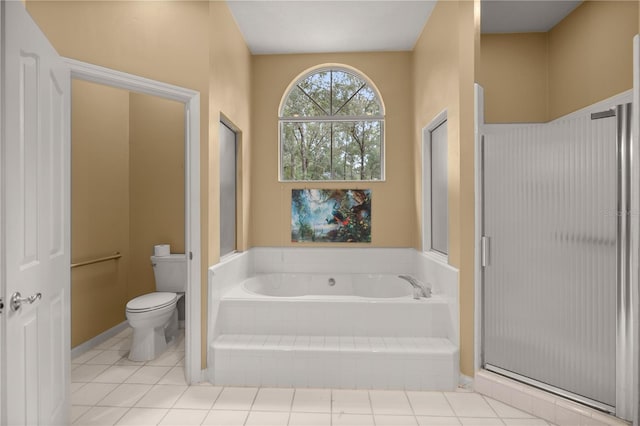 bathroom featuring tile patterned floors, toilet, a bath, and a stall shower