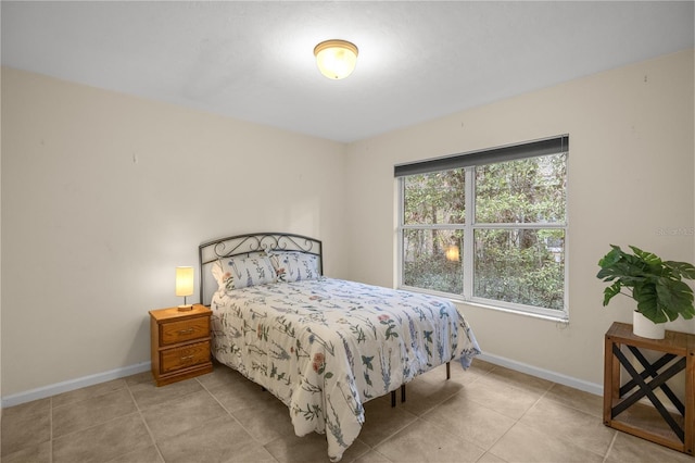 tiled bedroom featuring baseboards