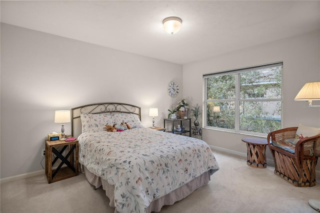 bedroom featuring light colored carpet and baseboards