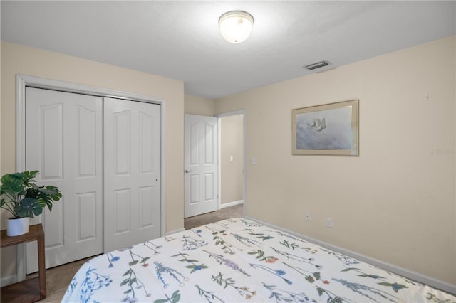 bedroom with a closet, visible vents, and baseboards