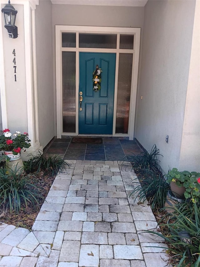entrance to property featuring stucco siding