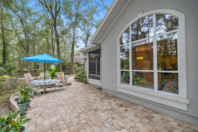 view of patio with a sunroom and fence