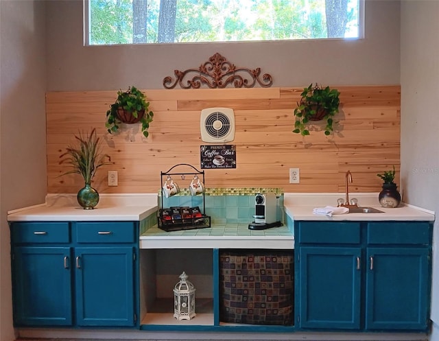 bar featuring wood walls, visible vents, and a sink