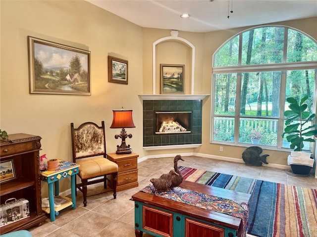 living area with recessed lighting, a wealth of natural light, tile patterned flooring, and a fireplace
