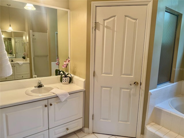 bathroom with a bath, vanity, and tile patterned flooring