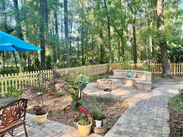 view of patio with fence and a fire pit