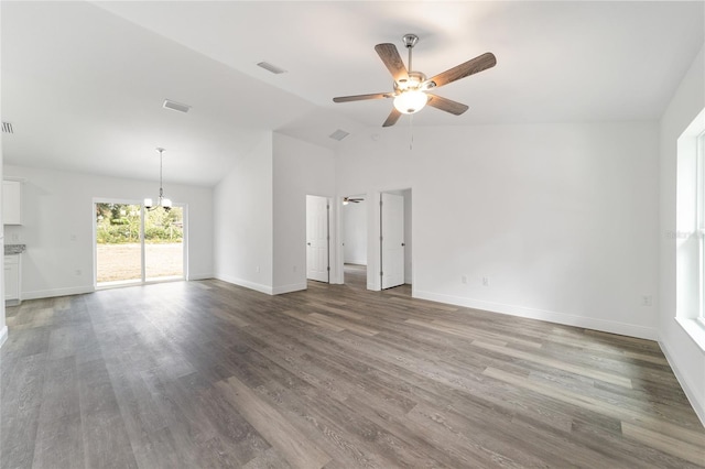 unfurnished living room featuring hardwood / wood-style flooring, lofted ceiling, and ceiling fan with notable chandelier