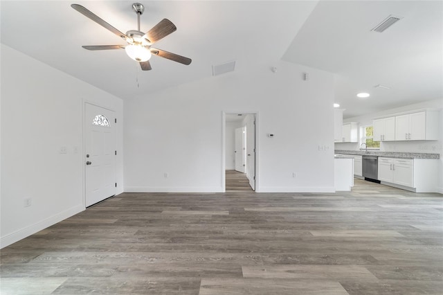 unfurnished living room featuring vaulted ceiling, light hardwood / wood-style flooring, and ceiling fan