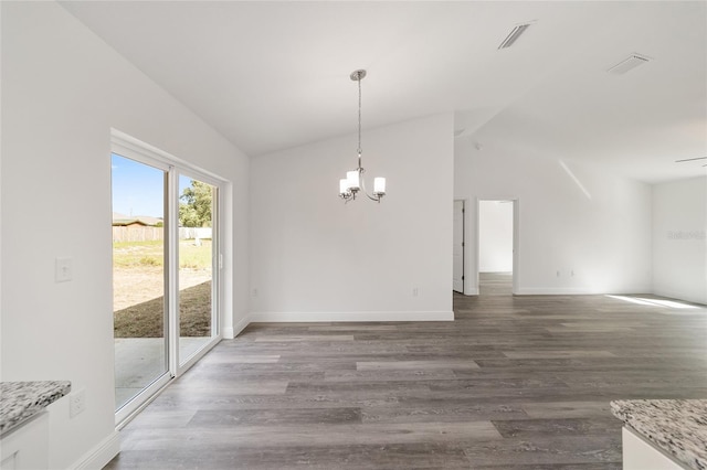 unfurnished dining area featuring a notable chandelier, vaulted ceiling, and dark hardwood / wood-style floors