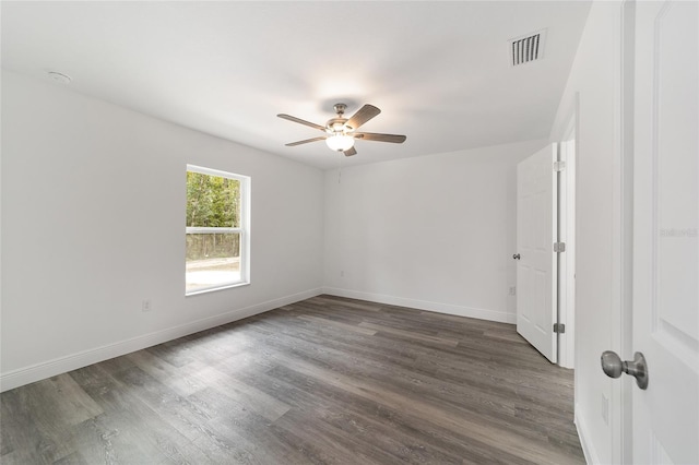 spare room with dark wood-type flooring and ceiling fan