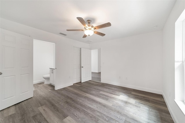 unfurnished bedroom with connected bathroom, ceiling fan, and dark hardwood / wood-style floors