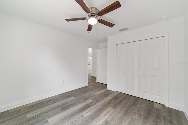 unfurnished bedroom featuring dark hardwood / wood-style flooring, a closet, and ceiling fan