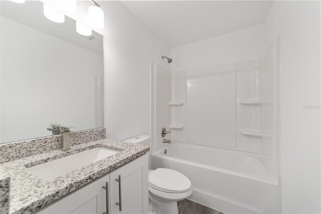 full bathroom featuring toilet, hardwood / wood-style flooring, vanity, and tub / shower combination