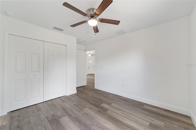 unfurnished bedroom with a closet, hardwood / wood-style flooring, and ceiling fan