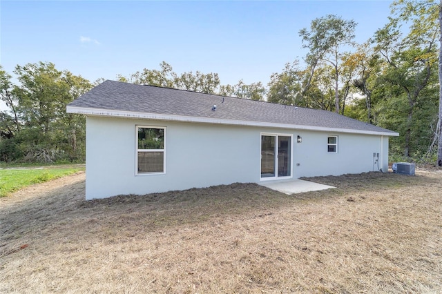 rear view of property featuring a patio, cooling unit, and a lawn