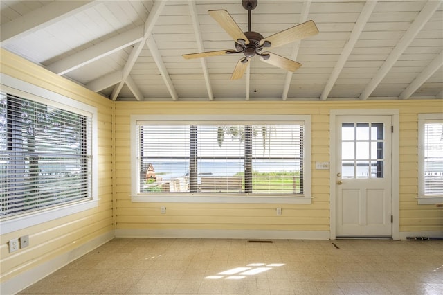 unfurnished sunroom featuring vaulted ceiling with beams, a healthy amount of sunlight, wooden ceiling, and ceiling fan