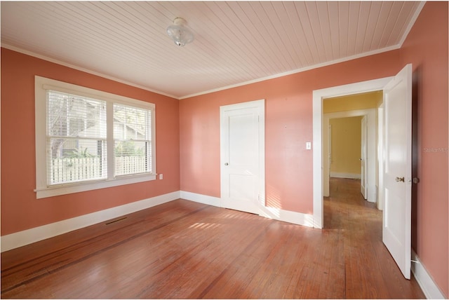 spare room with ornamental molding, hardwood / wood-style flooring, and wooden ceiling