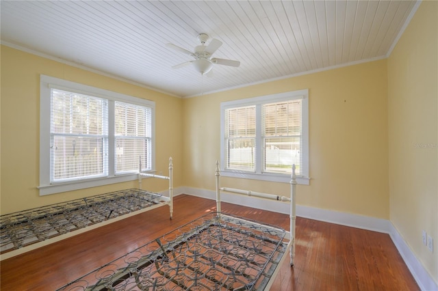 empty room with crown molding, wood-type flooring, wood ceiling, and ceiling fan