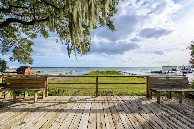 deck featuring a lawn and a water view