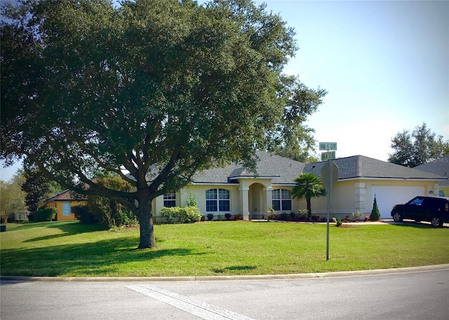 ranch-style house featuring a front lawn and a garage