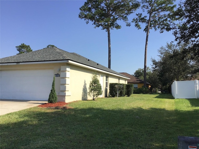 view of side of property with a garage and a lawn